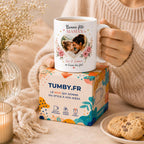Peut inclure: Mug blanc en céramique avec une anse, orné d'une photo en forme de cœur d'une mère et d'un enfant, entourée de motifs floraux. Le mug porte l'inscription "Bonne fête MAMAN" et "Léa & Emma on t'aime très fort".