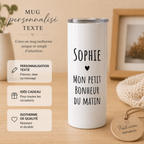 Mug isotherme blanc personnalisé avec prénom et texte noir, présenté sur table en bois dans une ambiance beige chaleureuse
