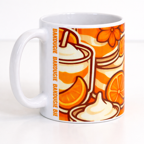 Mug blanc avec illustration orange d agrumes, tasse et creme, avec texte vertical BAKOUGIE pres de l anse, photographie en gros plan sur fond clair