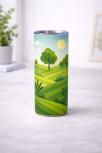 Tumbler haut avec decor illustre de paysage vert, vu de face sur une surface claire, avec collines, arbres, soleil et ciel clair, devant un fond interieur flou