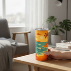 Main tenant un tumbler blanc avec couvercle transparent et illustration de plage tropicale, pose sur une table claire dans un interieur lumineux avec fauteuil, plante et livres